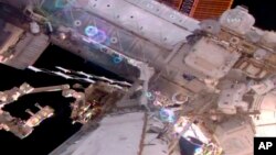 Esta imagen tomada del video en vivo proporcionado por la NASA muestra al astronauta Shane Kimbrough, a la derecha, que trabaja en la Estación Espacial Internacional durante un paseo espacial el viernes 24 de marzo de 2017. 