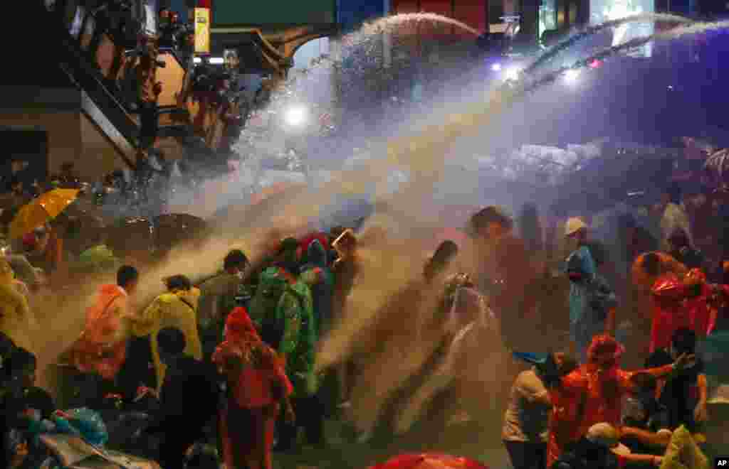 Pro-democracy demonstrators face water canons as police try to clear the protest venue in Bangkok, Thailand.
