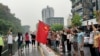 Anti-coup protesters hold a Chinese flag before burning it down during a demonstration against China in Yangon, Myanmar, April 5, 2021. 