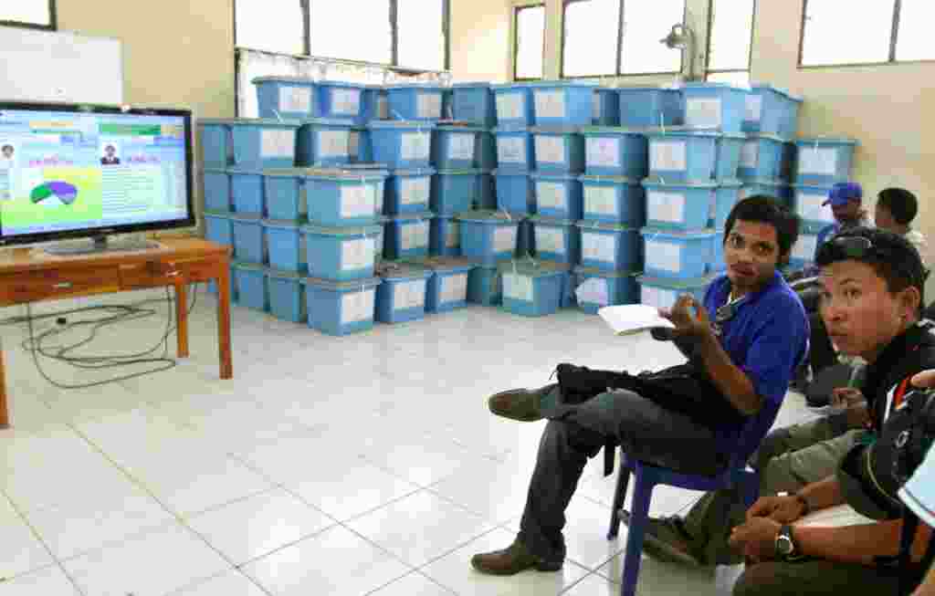 Warga menyaksikan hasil sementara pemilihan di televisi, Dili (18/3) (AP).