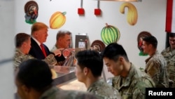 Presiden AS Donald Trump menyajikan makanan untuk pasukan AS di acara makan malam Thanksgiving selama kunjungan mendadak di Pangkalan Udara Bagram di Afghanistan, 28 November 2019. (Foto: Reuters/Tom Brenner)