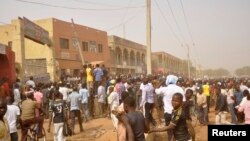 People rush to the scene of explosions at a bus park in Sabon Gari, where the Islamist group Boko Haram is waging an insurgency against the government, in Kano, Nigeria, March 19, 2013.