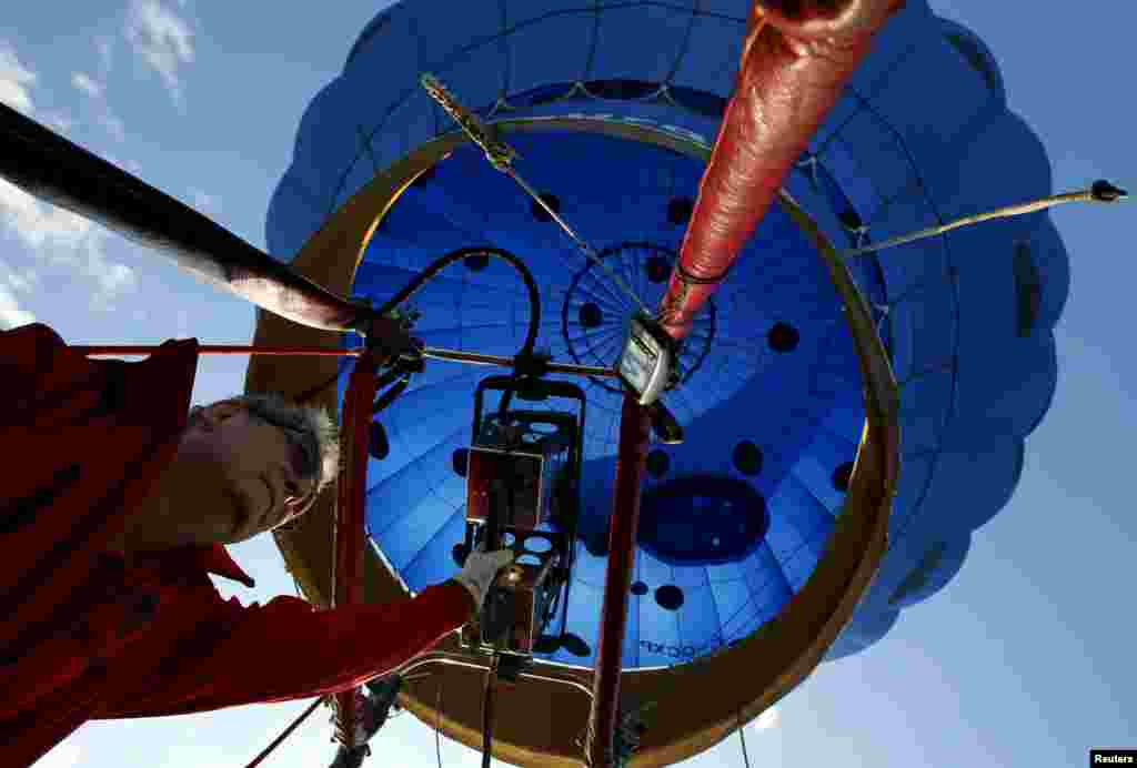 Normand Trepanier from Saint-Jean-Sur-Richelieu, Quebec, Canada, pilots the hot air balloon Piko on day one of the 2015 New Jersey Festival of Ballooning in Readington. More than 100 balloons are taking part in the three-day festival, one of the largest of its kind in North America.