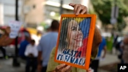 Un hombre sostiene una imagen de la líder opositora María Corina Machado durante una protesta contra la reelección del presidente Nicolás Maduro dos meses después de las disputadas elecciones en Caracas, el sábado 28 de septiembre de 2024. 