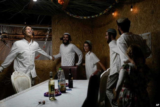 Israelis celebrate the news of the death of Hamas leader Yahya Sinwar, near Kibbutz Erez, southern Israel, on Oct. 17, 2024.