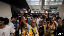 "Grandpa Wong," 85, shields protesters from the police by holding his walking stick up along with other "silver hair" volunteers in the Tung Chung district in Hong Kong, Sept. 7, 2019.