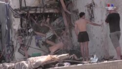 Իսրայելի Աշդոդ քաղաքի բնակիչները ցույց են տալիս Գազայի հրթիռից վնասված շենքը: