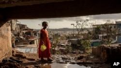 FILE - A young girl walks in the Kaweni slum on the outskirts of Mamoudzou, in the French Indian Ocean island of Mayotte, Dec. 19, 2024, after Cyclone Chido. 