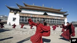 藏族僧人在四川一座寺庙前起舞