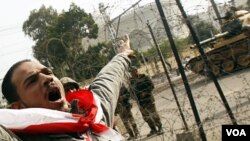 Un manifestante iracundo grita frente al palacio presidencial fuertemente custodiado por el ejército.