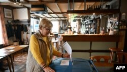 Seorang perempuan memasukan surat suara untuk pemilu Parlemen Eropa di sebuah kafe di Baarle-Nassau, di selatan Belanda, Kamis, 6 Juni 2024. (Foto: John Thys/AFP)