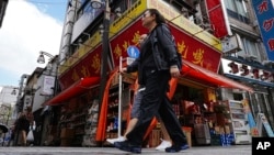 Commuters walk past a Chinese grocery store that's popular among Chinese living in Japan, Sept. 4, 2024, in Tokyo. Some Japan experts say Beijing’s transnational repression has created a chilling effect within the Chinese diaspora in Japan.