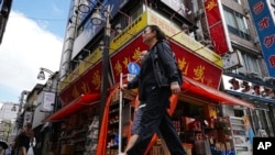 Para pejalan kaki melewati sebuah toko kelontong China yang populer di kalangan warga China yang tinggal di Tokyo, Jepang, pada 4 September 2024.(Foto: AP/Eugene Hoshiko)