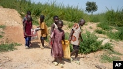 Juliet Samaniya, 6 ans, porte un sac de lithium avec d'autres enfants sur un site minier illégal à Paseli, au Nigeria, le mardi 5 novembre 2024. (AP/Sunday Alamba)