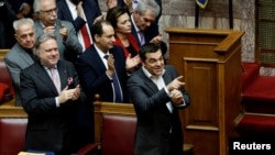 Greek Prime Minister Alexis Tsipras and members of his government applaud after a vote on an accord between Greece and Macedonia changing the former Yugoslav republic's name in Athens, Greece, January 25, 2019.