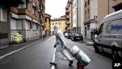 Özellikle Mart ayında Corona salgınının en büyük darbeyi indirdiği ülkelerden biri olan İtalya'nın kuzeyindeki Bergamo kentinde bir sağlık çalışanı, evinde Corona enfeksiyonu tedavisi gören bir hastaya oksijen tüpü taşıyor