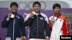 Silver medalist Japan's Takaharu Furukawa (L to R), gold medalist South Korea's Oh Jin Hyek and bronze medalist China's Dai Xiaoxiang pose during the victory ceremony for the men's individual archery event at the London 2012 Olympic Games at the Lord's C