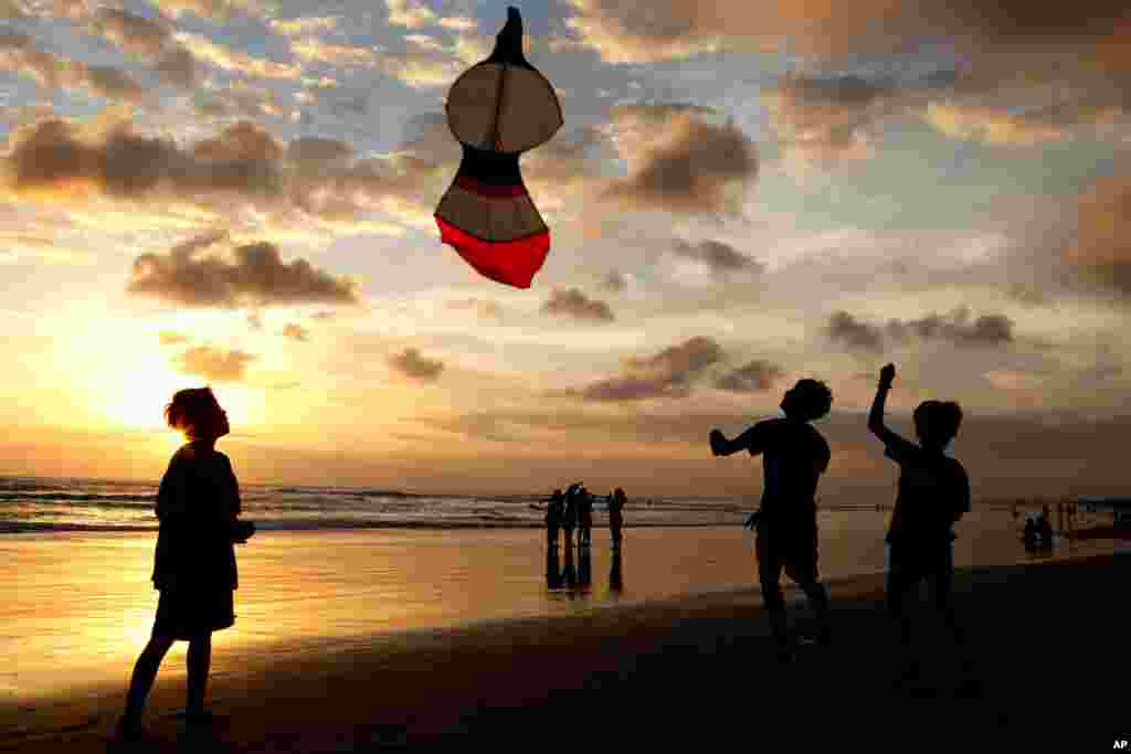 بچه ها در ساحلی در بالی اندونزی در حال هوا کردن کایت. سواحل بالی بعد از سه ماه قرنطینه بازگشایی شد. 