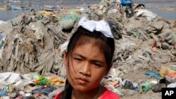 La activista ambiental Licypriya Kangujam, de 8 años, se encuentra en la playa de Juhu frente a un montón de basura durante una campaña de limpieza en Mumbai, India. Kangujam se encuentra entre los activistas climáticos más jóvenes.