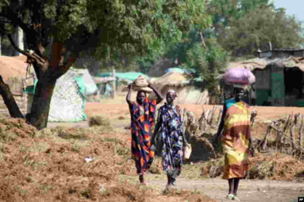Local residents walking through a neighborhood in Abyei town.
