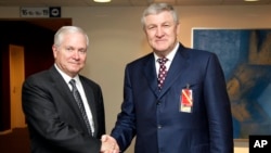 FILE - U.S. Defense Secretary Robert Gates, left, shakes hands with Ukrainian Defense Minister Mykhailo Yezhel at NATO headquarters in Brussels, June 10, 2010. Belarus has granted Yezhel, who is accused of embezzlement, refugee status.