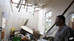 Rudy Luguna surveys the damage in his house he owns with his brother after the roof was ripped off in Tully, Australia, February 3, 2011