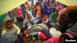 Rohingya refugees, who were on a boat traveling from Myanmar that capsized at Bailakhali beach, wait to transported to a refugee camp from the beach, near Cox's Bazar, Bangladesh, Oct. 31, 2017.