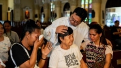 Pastor Flavie Villanueva mencoba menenangkan para kerabat dari korban pembunuhan dalam perang melawan narkoba di Filipina, sebelum misa berlangsung di Quezon City, Manila, pada 11 Maret 2025. (Foto: Reuters/Lisa Marie David)