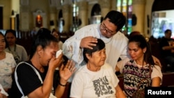 Pastor Flavie Villanueva mencoba menenangkan para kerabat dari korban pembunuhan dalam perang melawan narkoba di Filipina, sebelum misa berlangsung di Quezon City, Manila, pada 11 Maret 2025. (Foto: Reuters/Lisa Marie David)