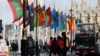 FILE PHOTO: People ride a bus past flags representing Commonwealth countries next to Westminster Abbey in London