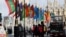 FILE PHOTO: People ride a bus past flags representing Commonwealth countries next to Westminster Abbey in London