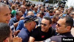 FILE - Police members push back supporters of Tunisia's Islamist opposition party Ennahda protesting in support of the party leaders, Rached Ghannouchi and Ali Larayedh, who were facing questioning by anti-terrorism police in Tunis,Tunisia September 19, 2022.
