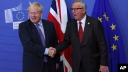 英国首相约翰逊与欧盟委员会主席容克在布鲁塞尔的欧盟总部握手。（2019年10月17日）