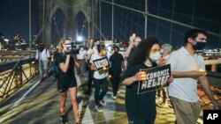 Protesters arrive at the Brooklyn Bridge after a march from the Barclays Center in New York, Aug. 21, 2020. Grieving families organized the "March for the Dead" to mourn American losses during the coronavirus pandemic.