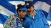 ARCHIVO - El presidente de Nicaragua, Daniel Ortega, conversa con la primera dama, Rosario Murillo, durante un acto oficial en mayo de 2022.