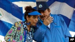 ARCHIVO - El presidente de Nicaragua, Daniel Ortega, conversa con la primera dama, Rosario Murillo, durante un acto oficial en mayo de 2022.