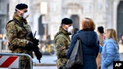 Italian soldiers wearing sanitary masks patrol Duomo square in downtown Milan, Italy, Feb. 24, 2020.