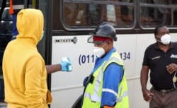 A mine worker has his temperature taken before his shift, during a nationwide lockdown due to the COVID-19 outbreak, at a mine of Sibanye-Stillwater company in Carletonville, South Africa, May 19, 2020.