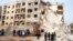 Syrians gather next to the scene of an explosion in Aleppo, January 18, 2013.
