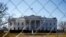 In this March 4, 2013, photo, The White House is seen through a chain-link fence where the inaugural reviewing stand once stood in Washington.