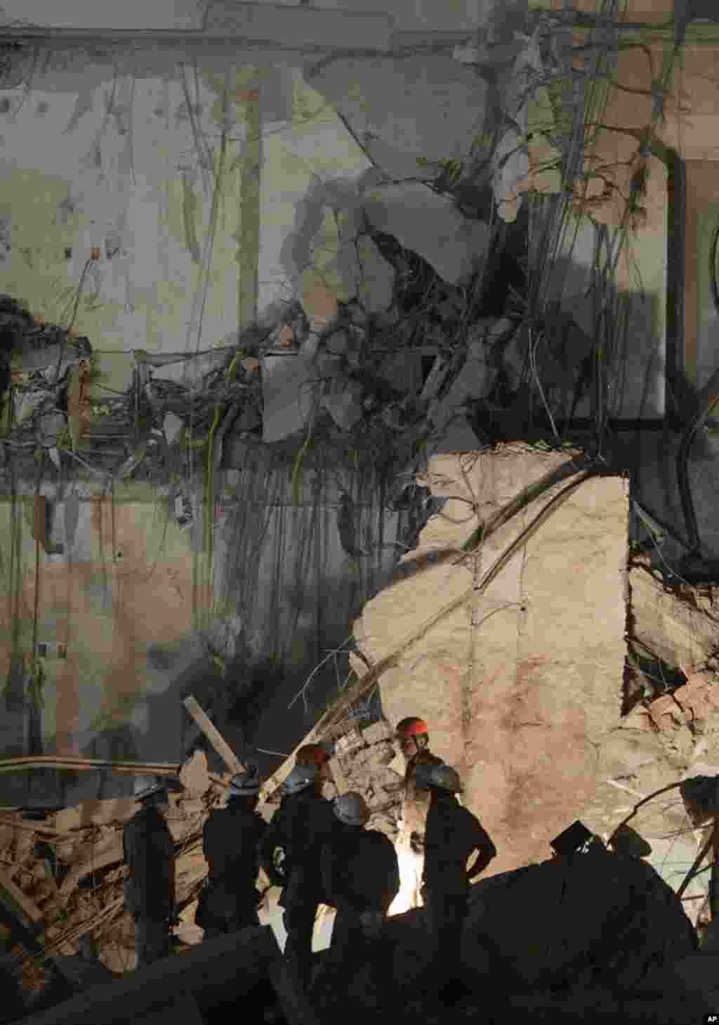 Firefighters work among the debris of a collapsed building in Rio de Janeiro. January 25, 2012. (Reuters)
