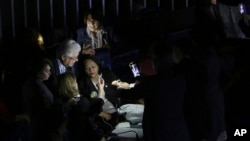 With the lights off, opposition Senators Gleisi Hoffmann, far left, Fatima Bezerra, center middle, and Vanessa Grazziotin, far right, top, address the press as they sit in the Senate leader area to prevent a vote on labor reform in Brasilia, Brazil, July 