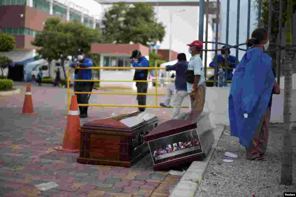 La gente espera junto a los ataúdes fuera del Hospital General Guasmo Sur después de que Ecuador informó nuevos casos de enfermedad por coronavirus.