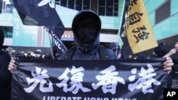资料照- 一位人在台湾的香港居民手举“Liberate Hong Kong”横幅在台湾街头抗议中国当局扣留12名香港人。(美联社照片）