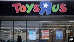 People walk near the entrance to a Toys 'R' Us store, Jan. 24, 2018, in Wayne, New Jersey.