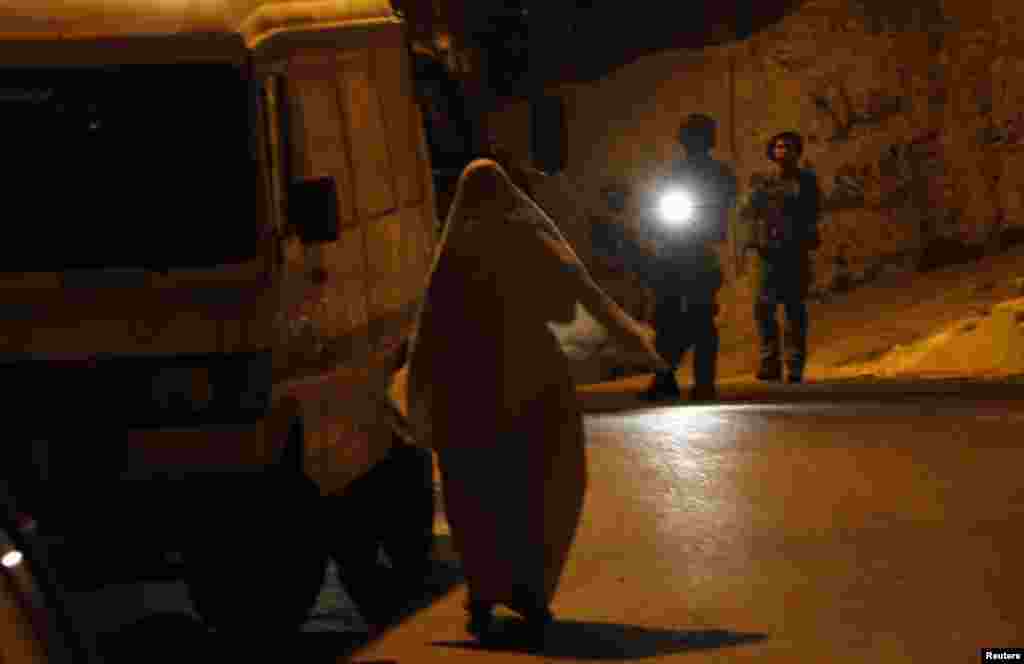 A Palestinian woman argues with Israeli soldiers in the West Bank city of Hebron, June 15, 2014.