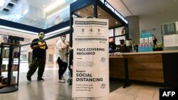 FILE - Social distancing instructions are seen at the Westfield Santa Anita shopping mall in Arcadia, California, June 12, 2020.