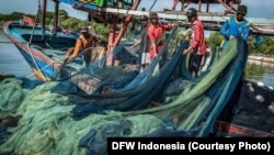 Sejumlah nelayan sedang membereskan jaring sebelum mulai melaut. Jaring-jaring nelayan di Indonesia masih menggunakan bahan yang tidak ramah lingkungan seperti plastik dan nilon. (Foto: DFW Indonesia)