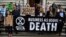 Climate change activists stage a protest outside the H M Treasury building in central London, April 25, 2019, during environmental protests by the Extinction Rebellion group.