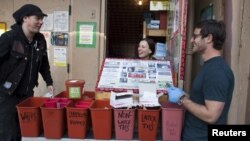 FILE - Shilo Murphy, Misty Kohal, and Jeff Sablosky, from left, prepare to open the People's Harm Reduction Alliance, the nation's largest needle-exchange program, in Seattle, Washington, April 30, 2015. The People's Harm Reduction Alliance hands out free meth pipes in the hopes that drug users may steer away from needles, which is one way to contract hepatitis C.